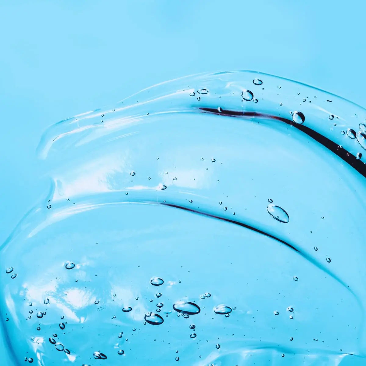 Nahaufnahme einer Flüssigkeit vor einen blauen Hintergrund 